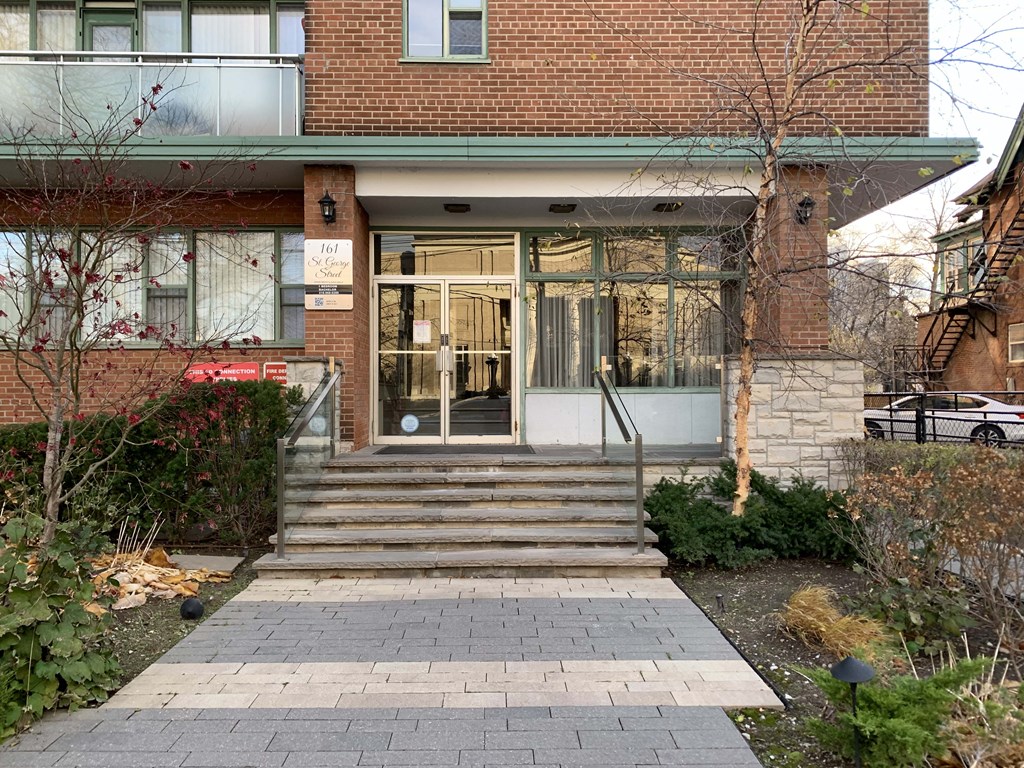 the front of a brick building with stairs and a glass door at 161 St. George, Toronto, CA