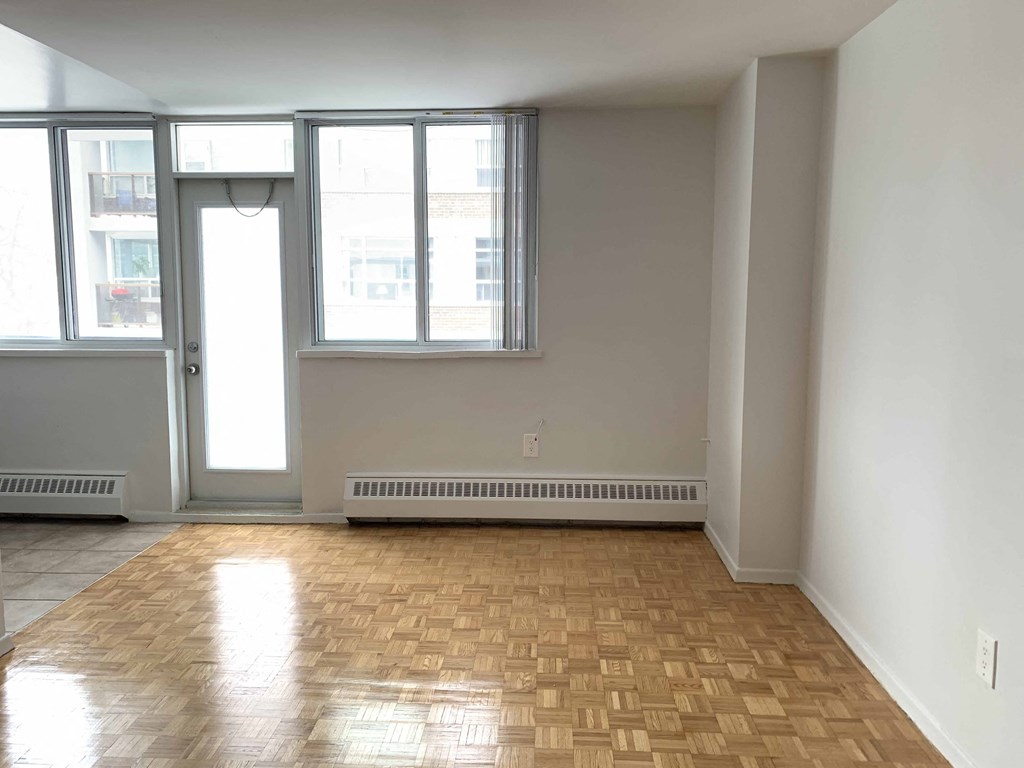 an empty living room with wood floors and windows