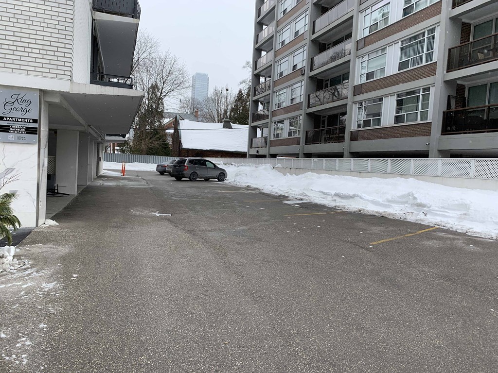 a car parked in a parking lot next to an apartment building