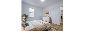 A bedroom with a bed, nightstand, and a painting on the wall. at 83-85 Silver Birch, Toronto Canada