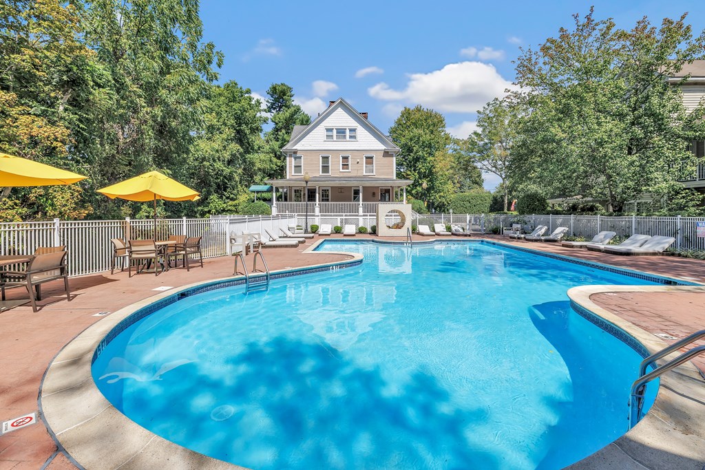 A swimming pool surrounded by a fence and trees.