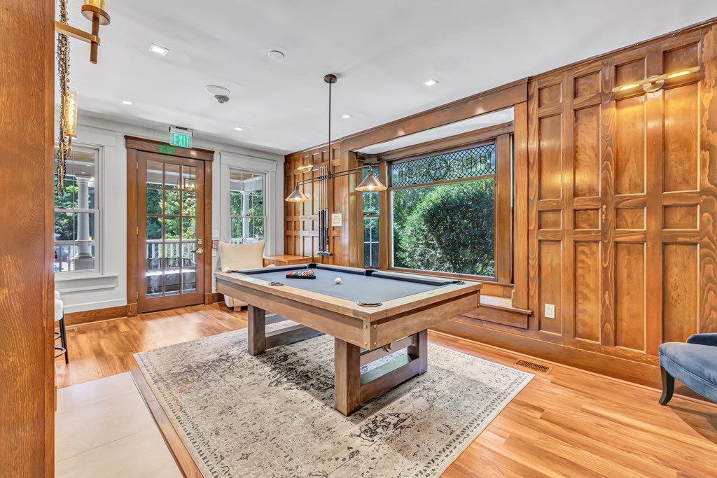 A pool table is in the middle of a room with wood paneling.