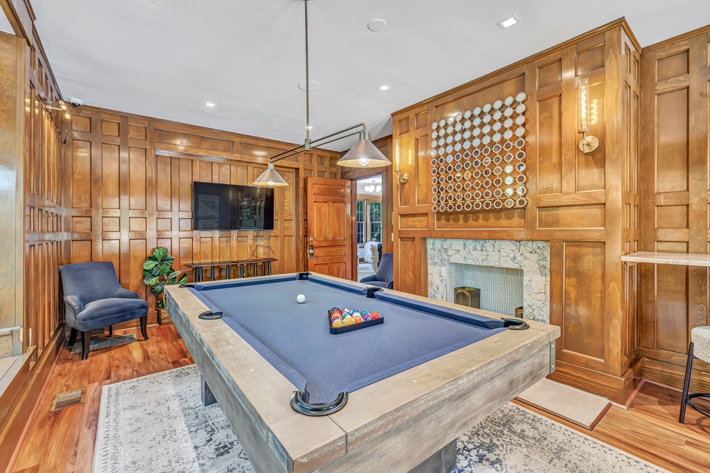 A pool table is in the middle of a room with wood paneling.