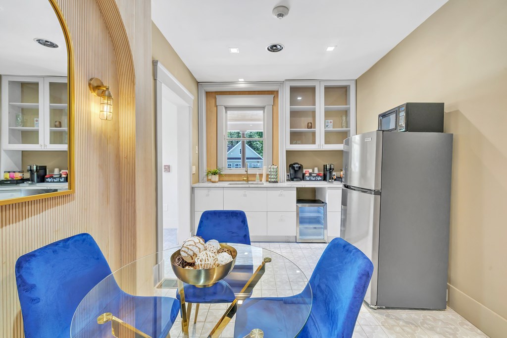 A modern kitchen with a dining table and blue chairs.