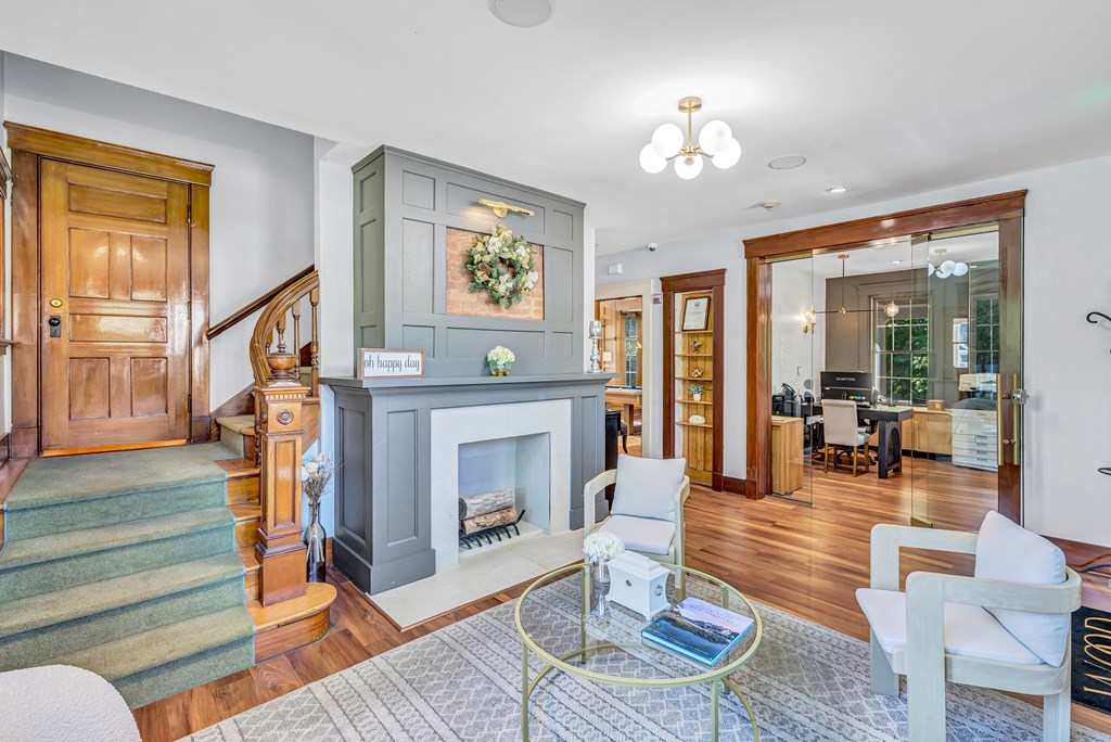 A living room with a fireplace and a glass coffee table.