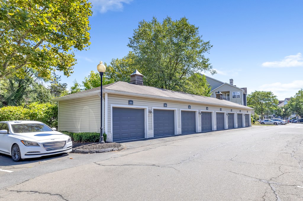 A white car is parked in front of a garage.