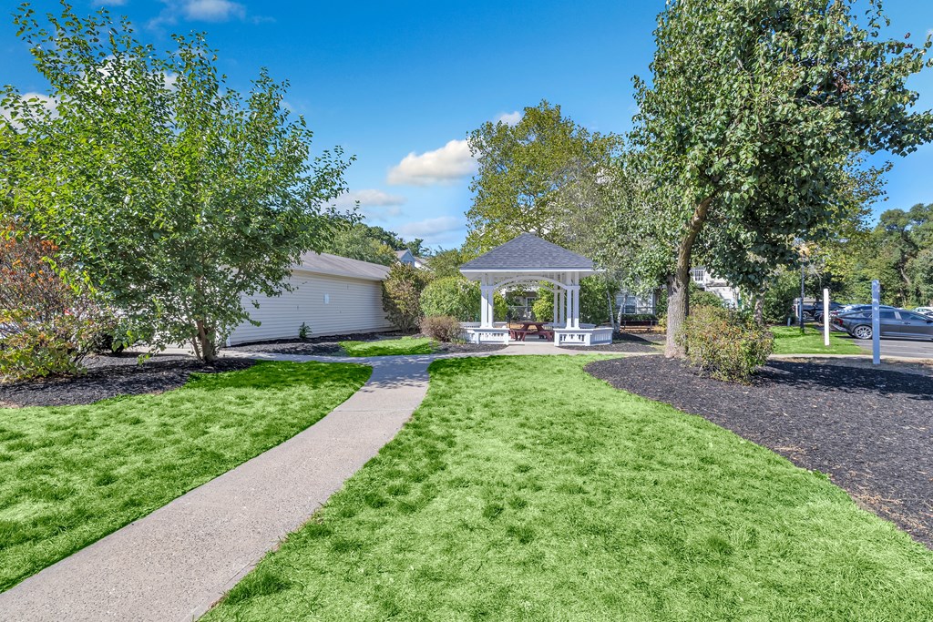 A well-maintained garden with a gazebo and a paved walkway.