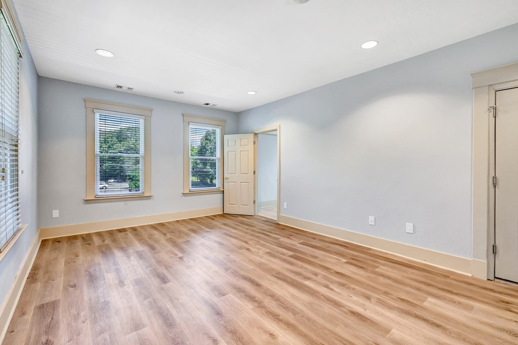 A room with wooden flooring and white walls.