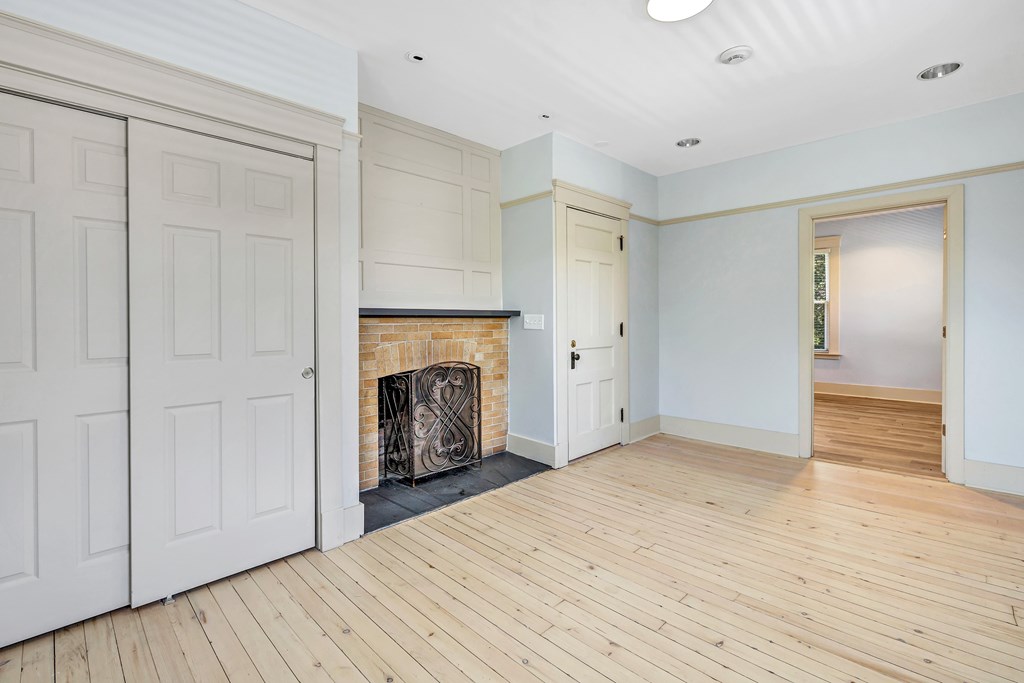 A room with a fireplace and wooden floors.