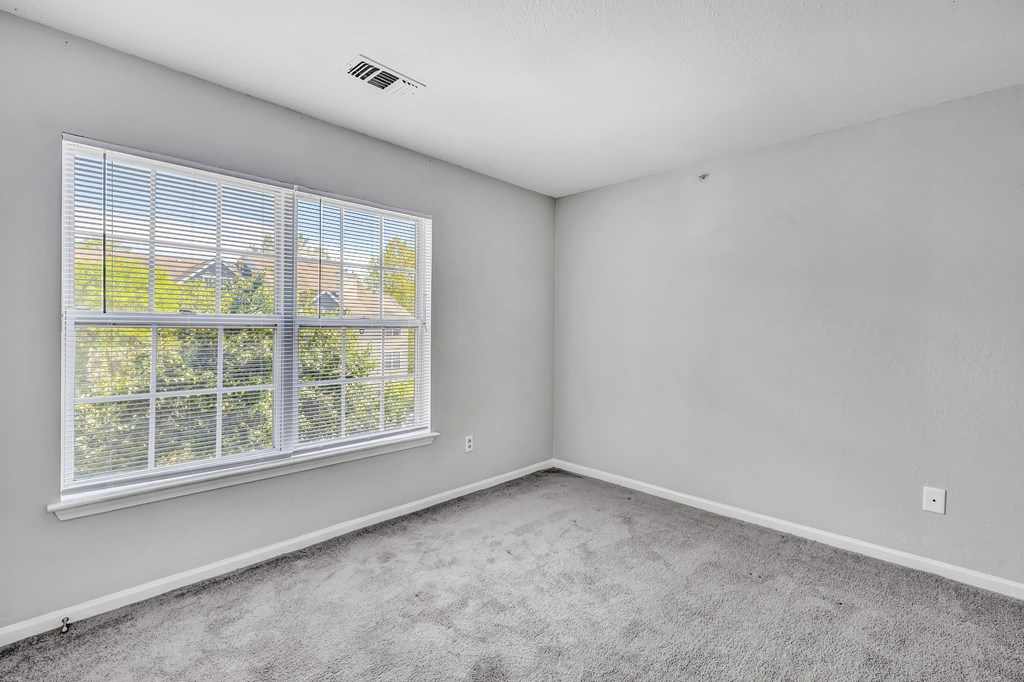 A room with a window overlooking a house.