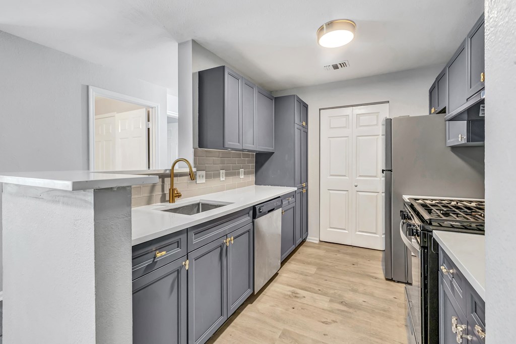 A kitchen with a white door and a sink.