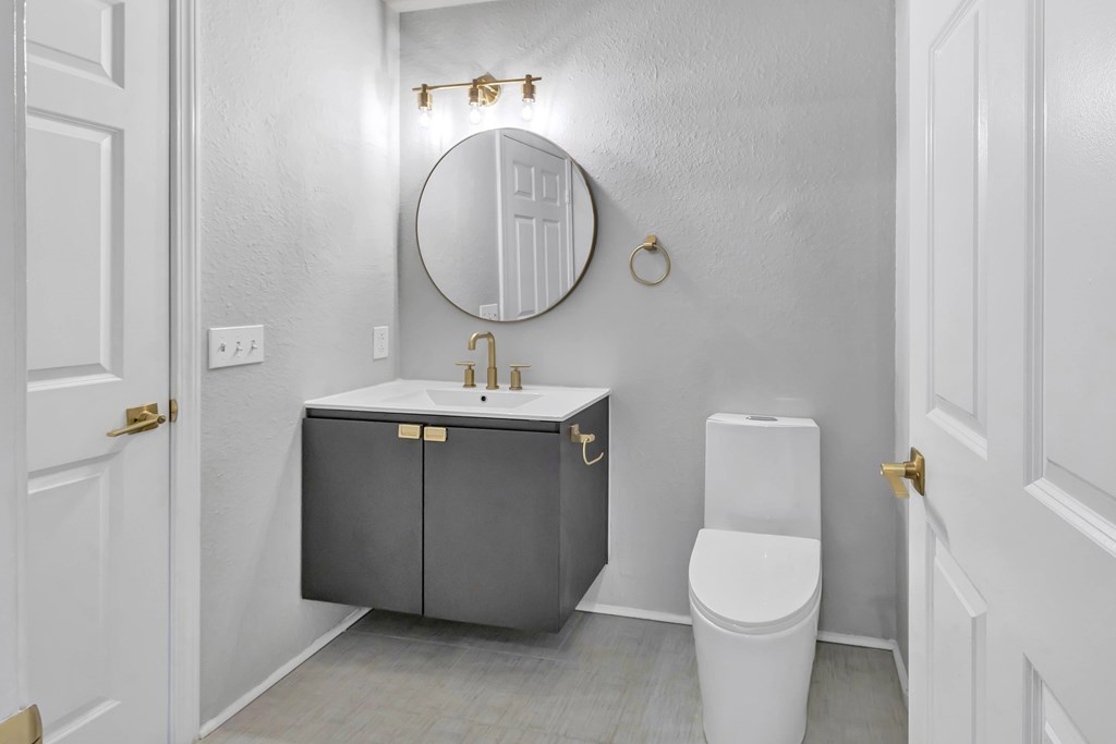 A bathroom with a white toilet and a sink with a cabinet above it.