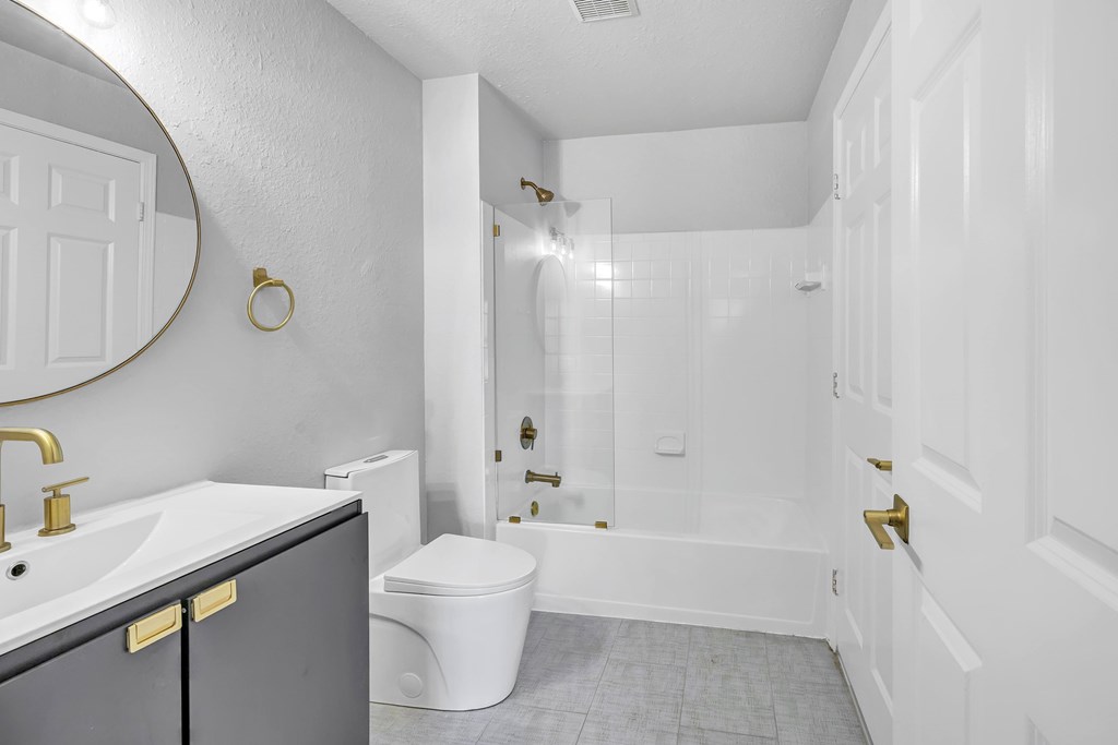 A bathroom with a toilet, sink, and bathtub.