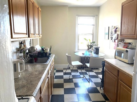 A kitchen with a checkered floor and a table with chairs.