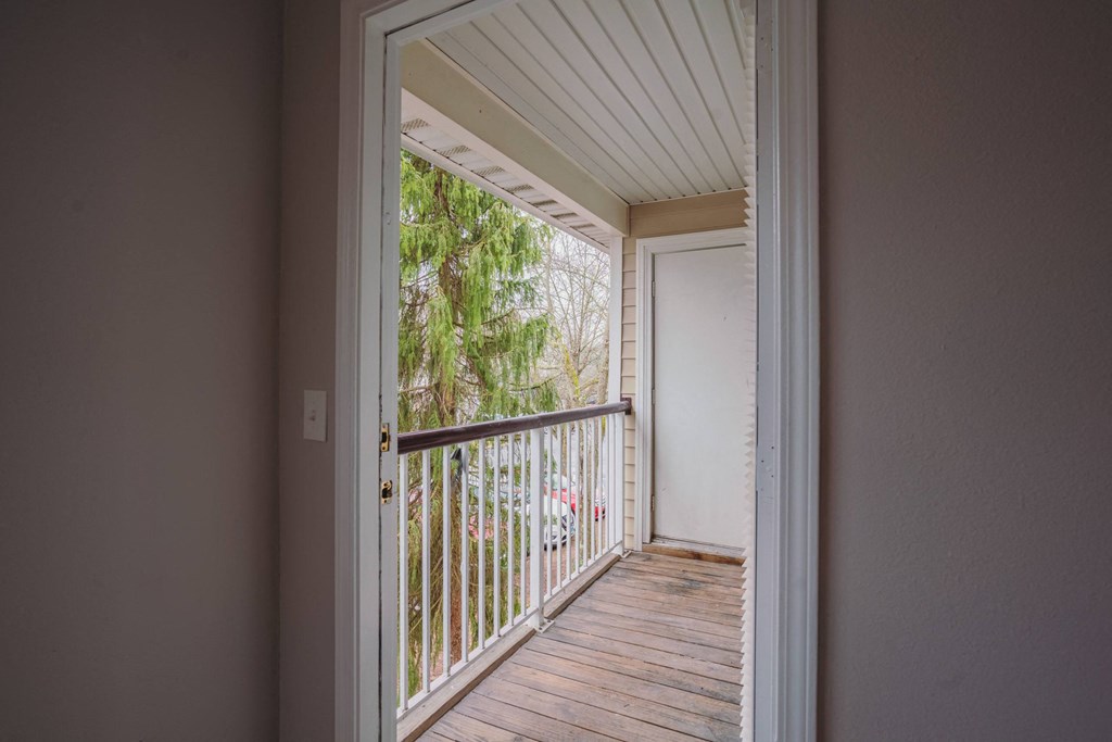 the view of a balcony from a room with a door open