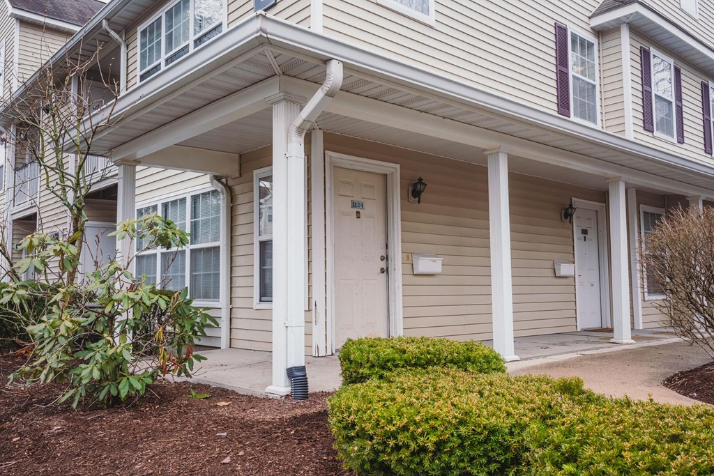 the front of a house with a porch and a white door