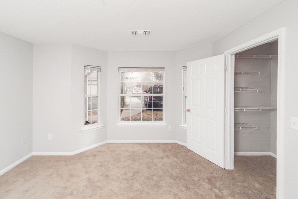 an empty room with a closet and a window