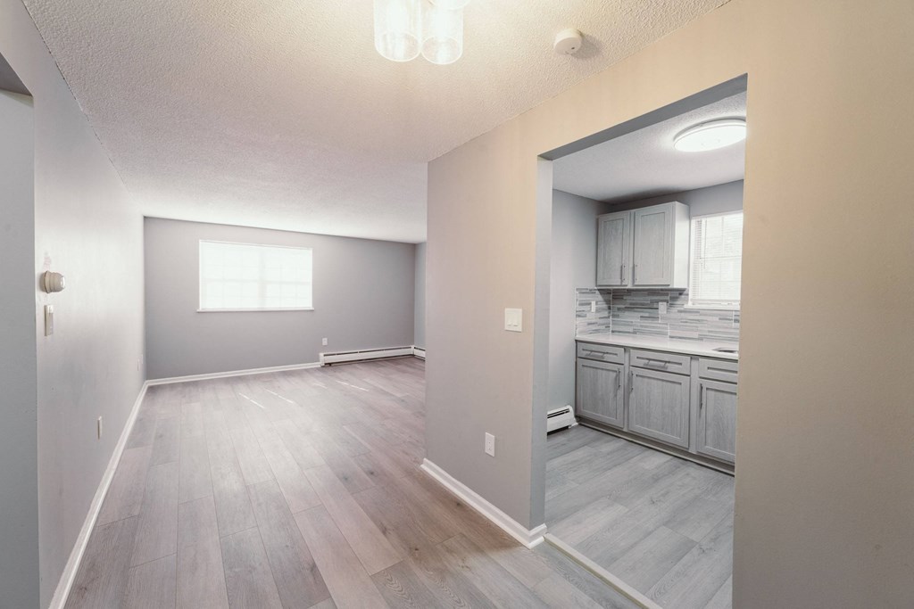 an empty living room and kitchen with wood floors and a window at BAY SHORE APARTMENTS, EAST HAVEN, CT, 06512