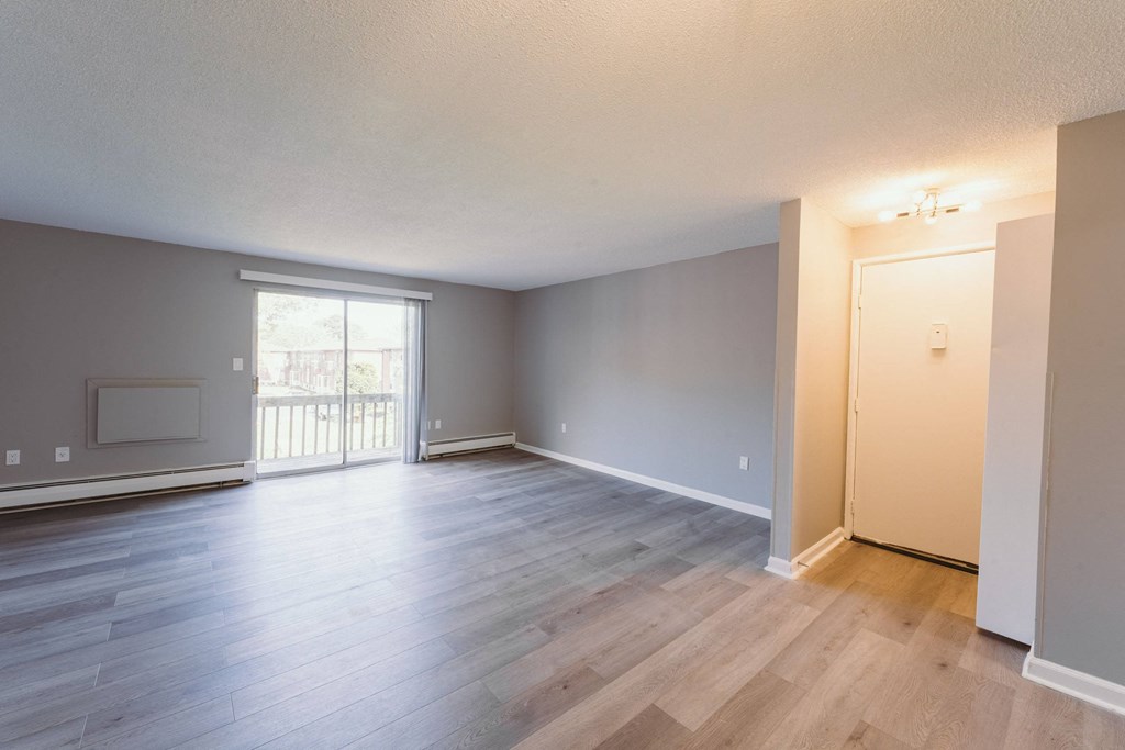 a living room and dining room of an empty house with wood flooring  at BAY SHORE APARTMENTS, EAST HAVEN, 06512