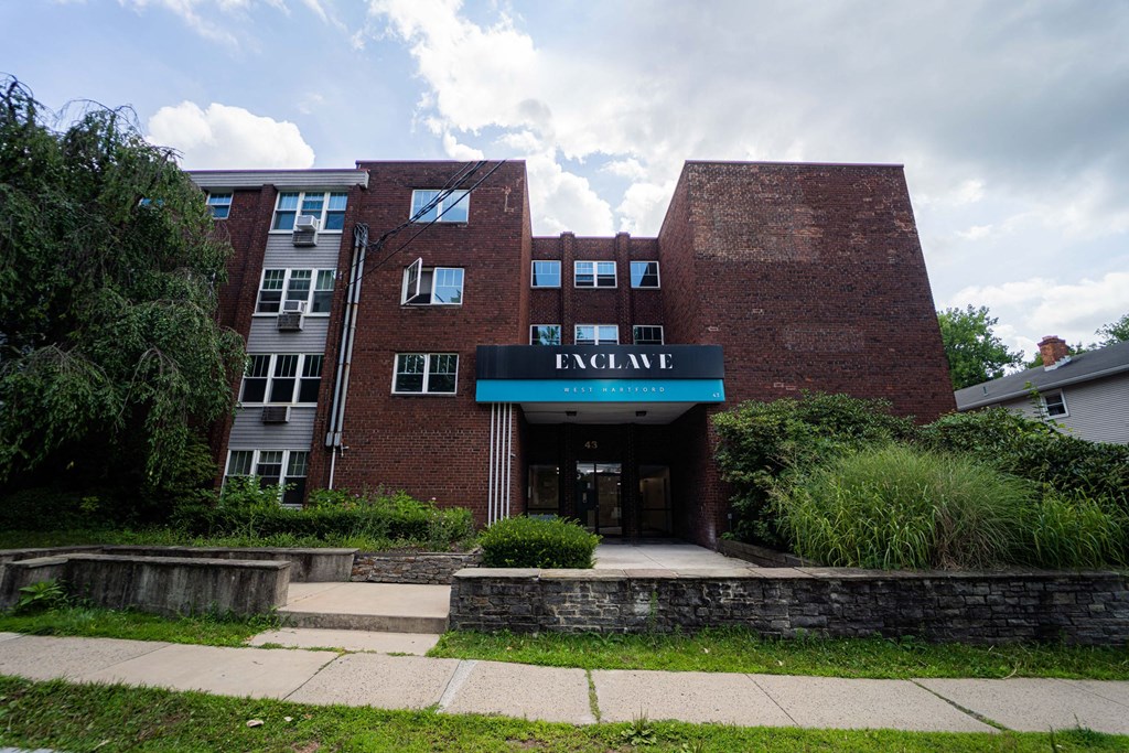 a large brick building with a blue sign in front