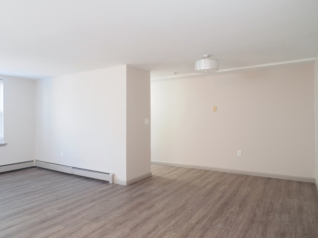 an empty living room with white walls and wood floors