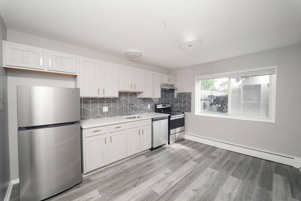 an empty kitchen with stainless steel appliances and white cabinets at Encore 99, East Haven, 06512