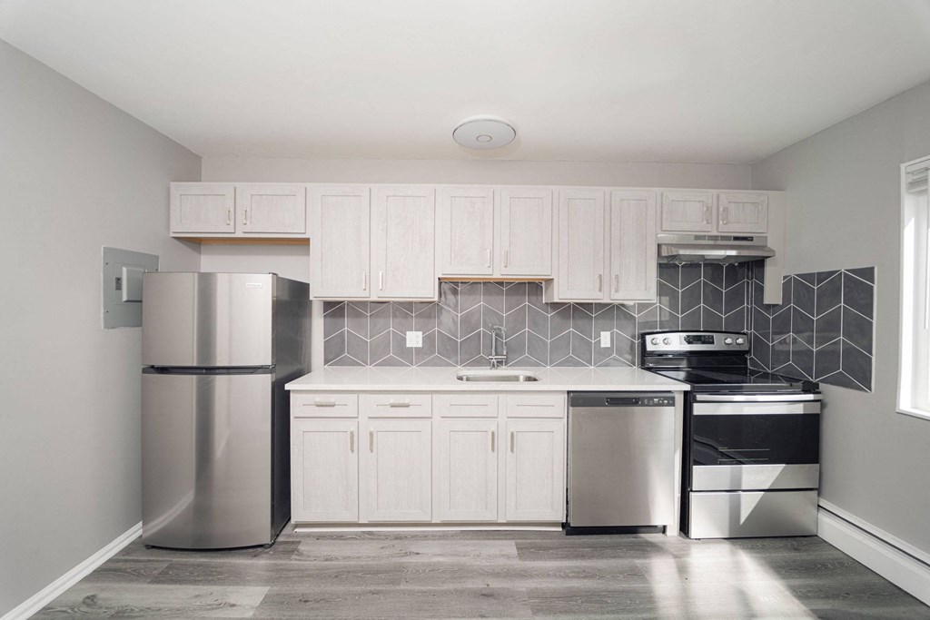 a kitchen with white cabinets and a stainless steel refrigerator at Encore 99, East Haven, CT, 06512