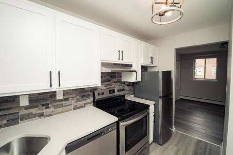 a kitchen with stainless steel appliances and white cabinets at Five High, West Hartford, 06119