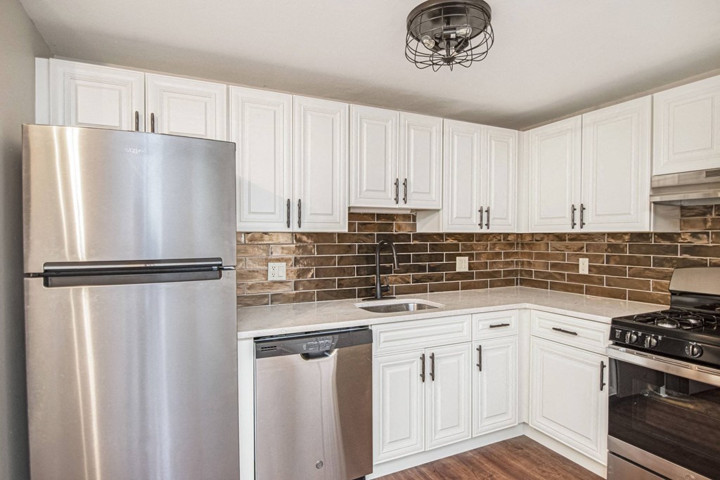 a kitchen with stainless steel appliances and white cabinets