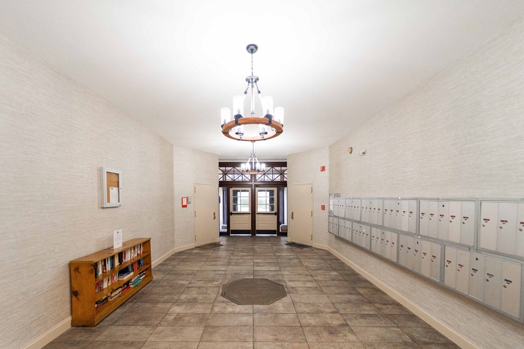a long hallway with rows of lockers and a chandelier