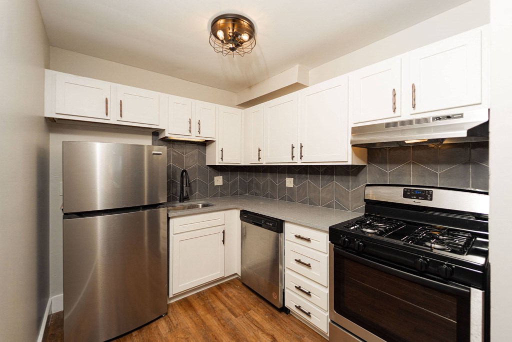a kitchen with stainless steel appliances and white cabinets