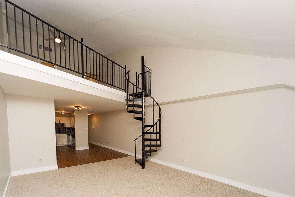 the loft of a home with a spiral staircase