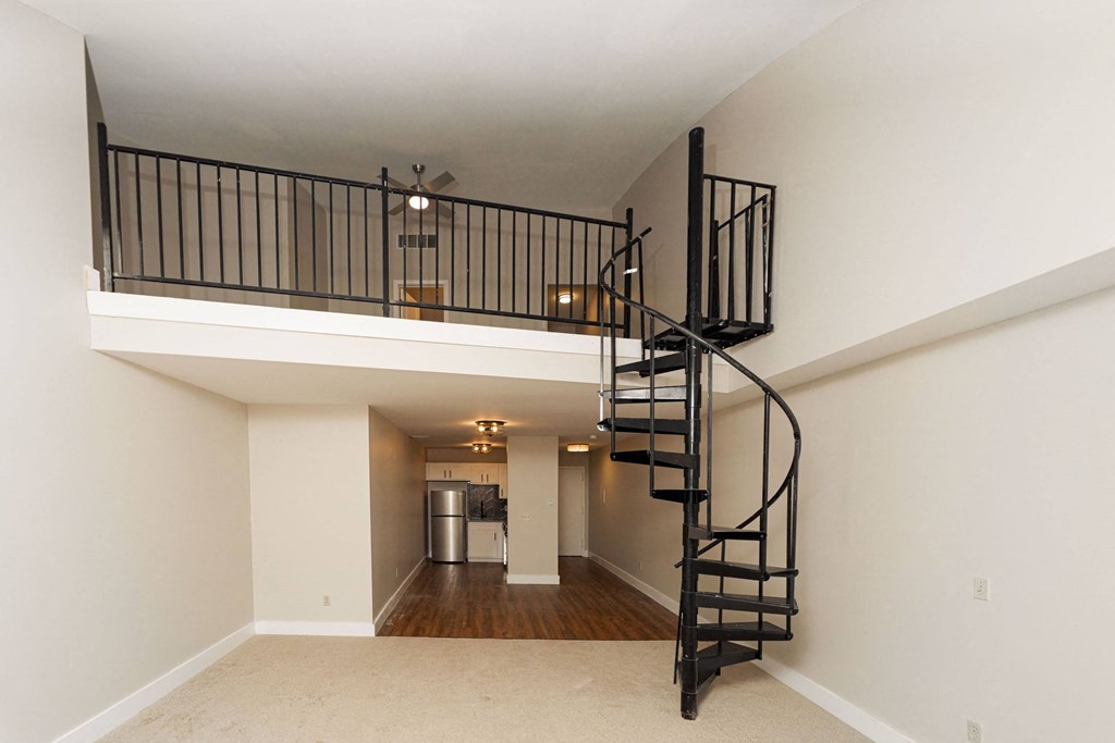 the loft in the great room of a house with a spiral staircase