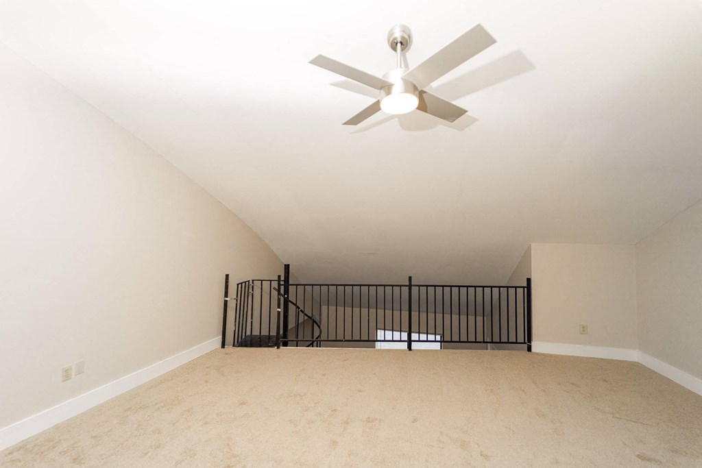 the spacious living room with a ceiling fan in a new home