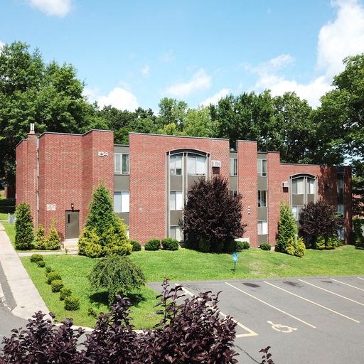 a red brick building with a lawn in front of it