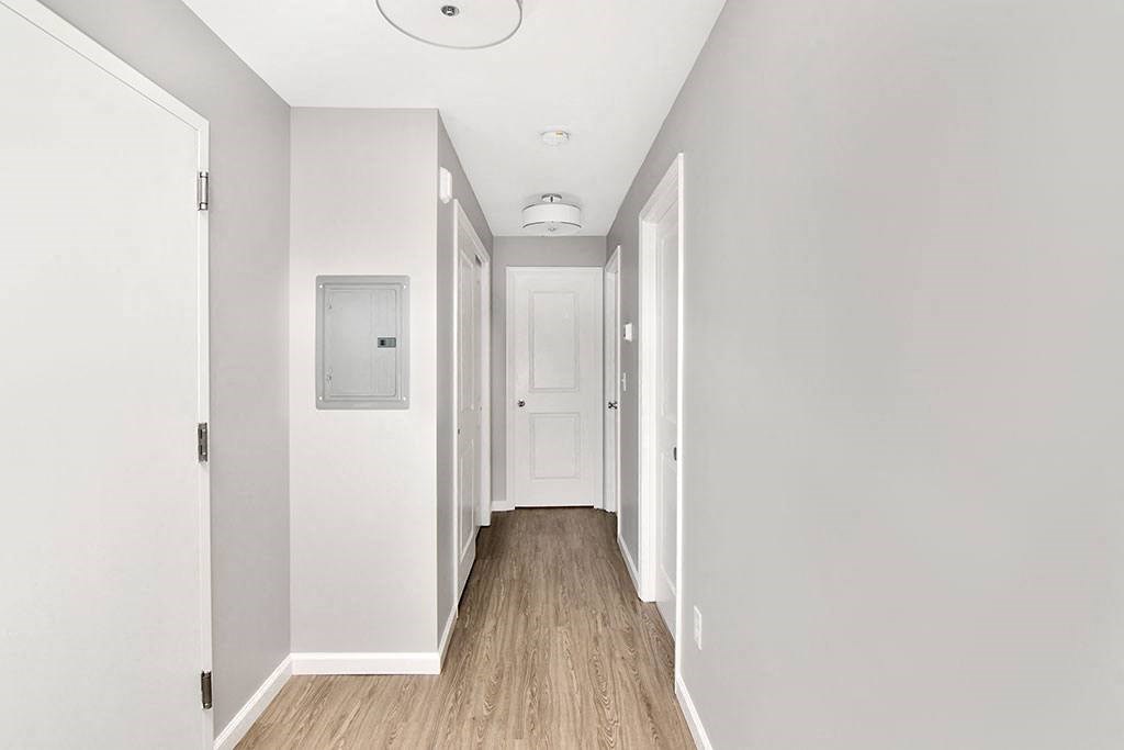 a long hallway with white walls and a white door