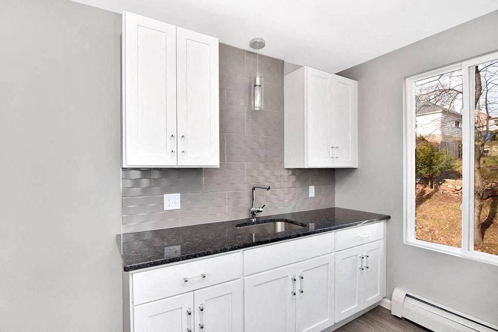 a kitchen with a sink and white cabinets