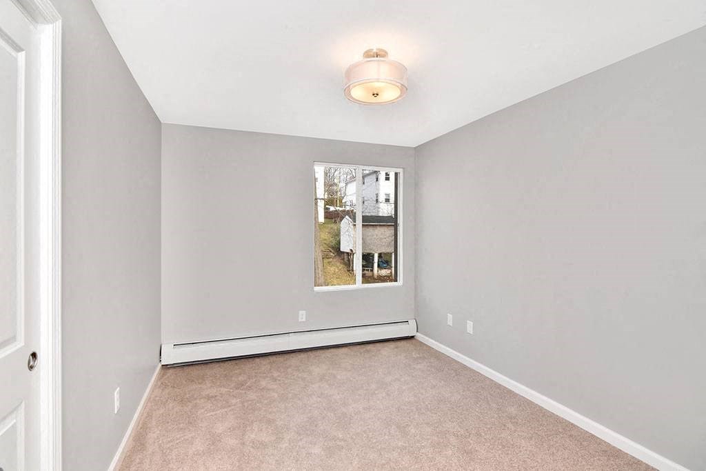 an empty room with a window and a carpet