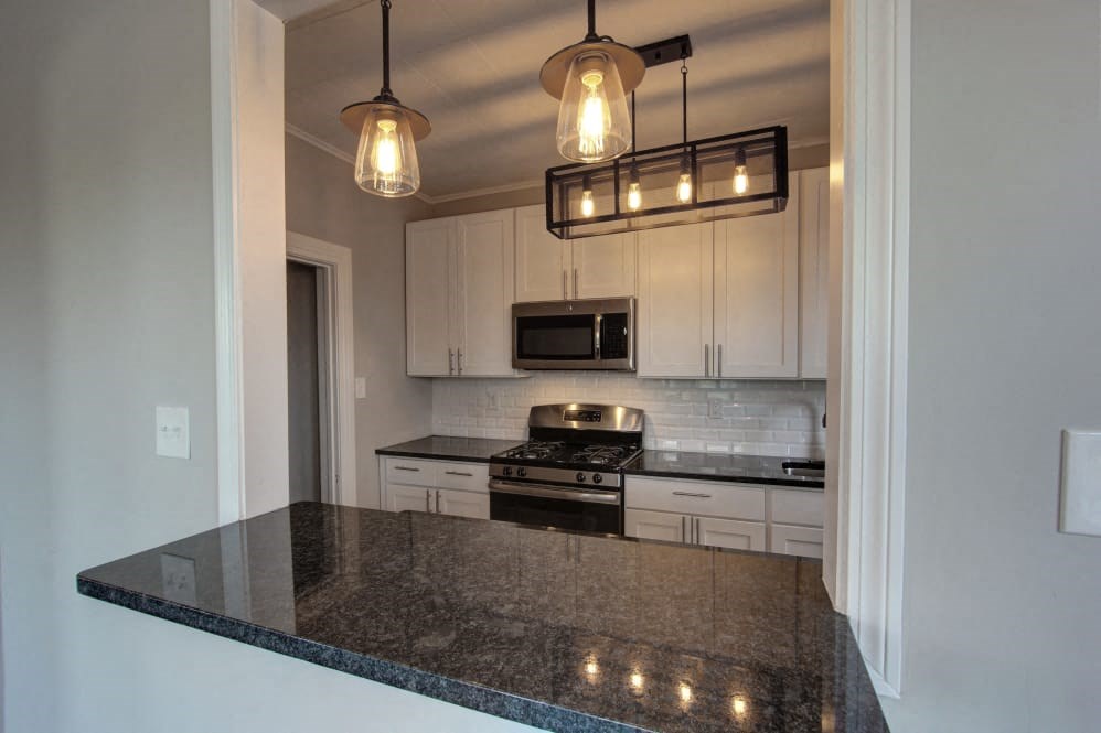 a kitchen with white cabinets and a counter top