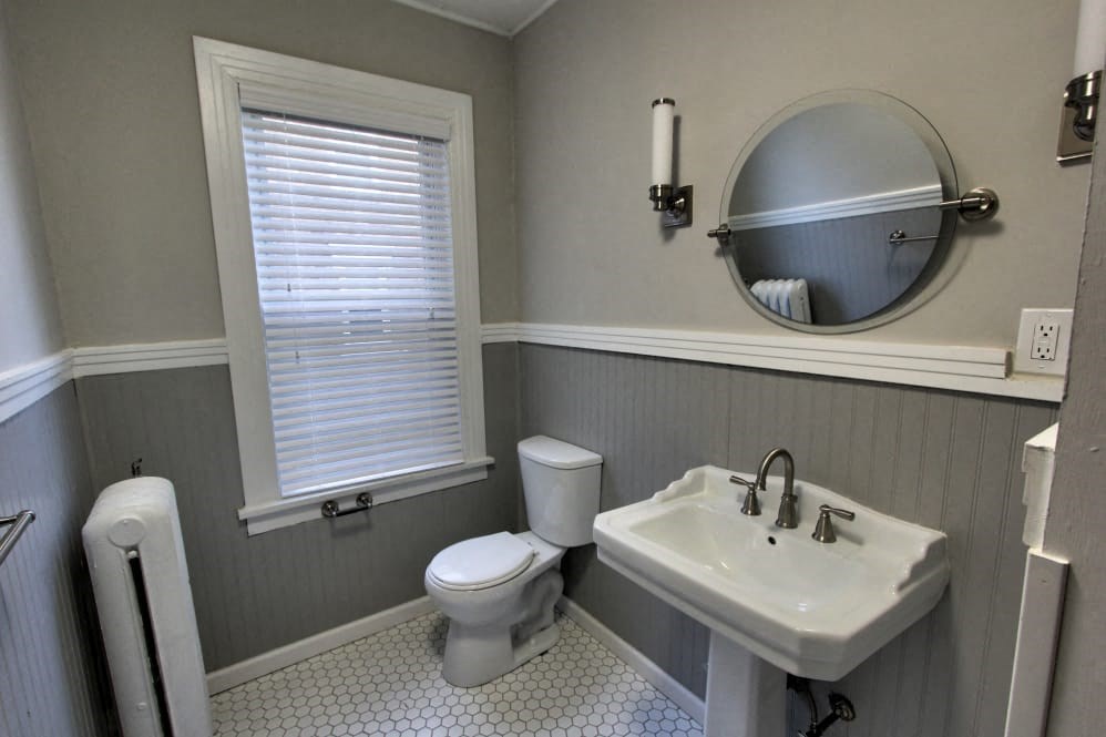 a bathroom with a sink toilet and a mirror