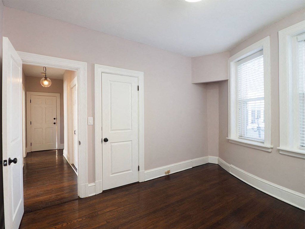an empty living room with wood floors and a white door