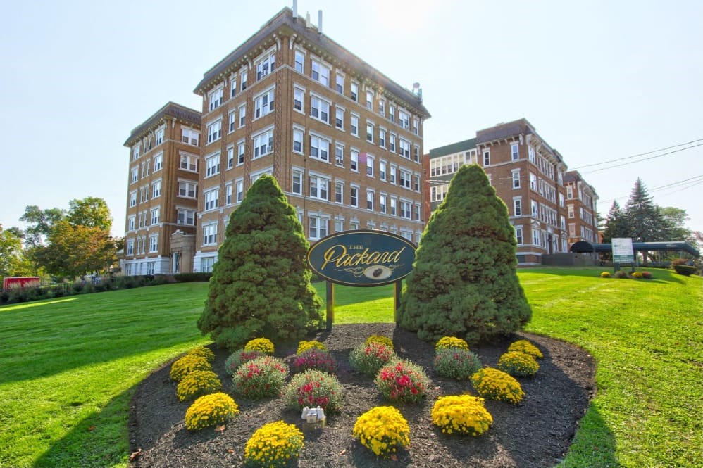 a garden with two trees and a sign in front of a building