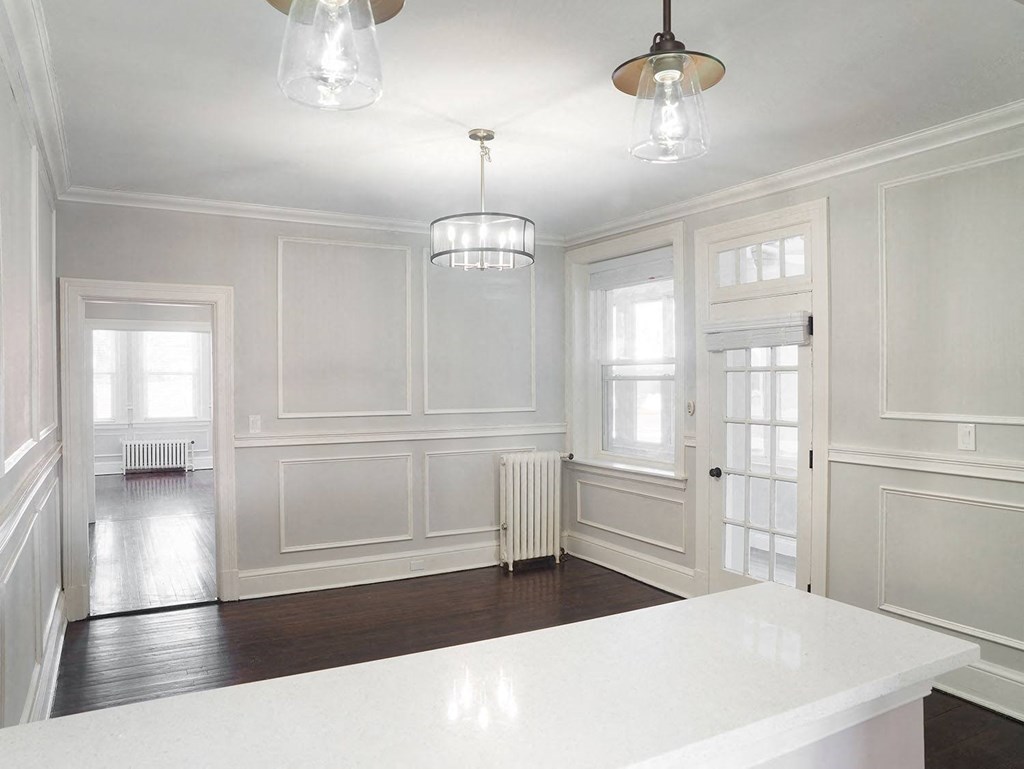 an empty kitchen with white walls and a white counter top