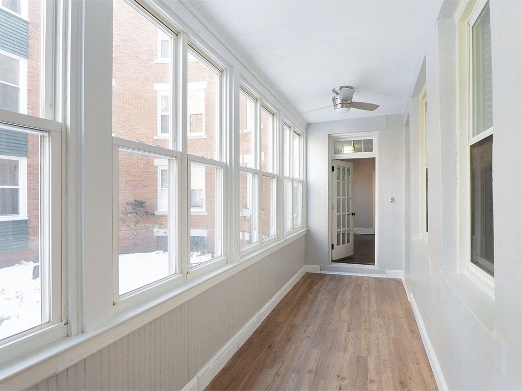 a living room with many windows and a wood floor