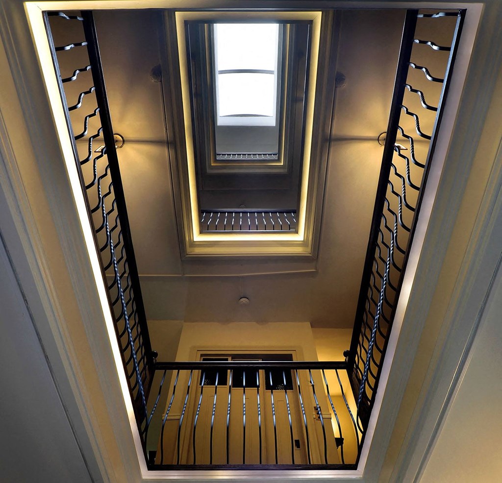 a view down the stairs of a building with a skylight