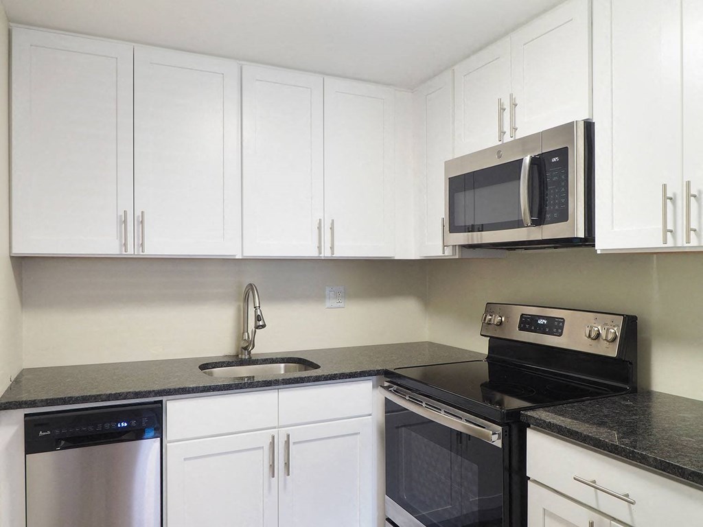 a kitchen with white cabinets and a stove and a microwave