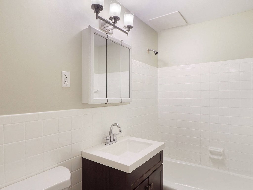 a white bathroom with a sink and a mirror