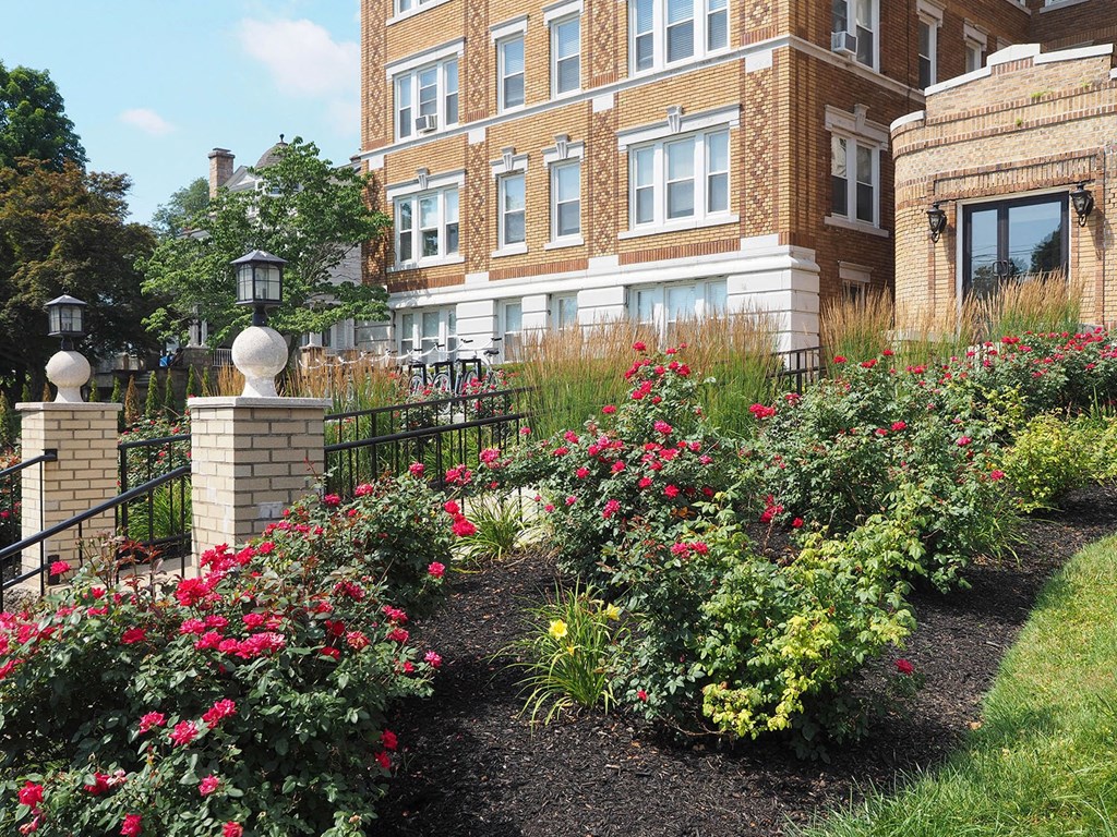 a garden in front of a brick building