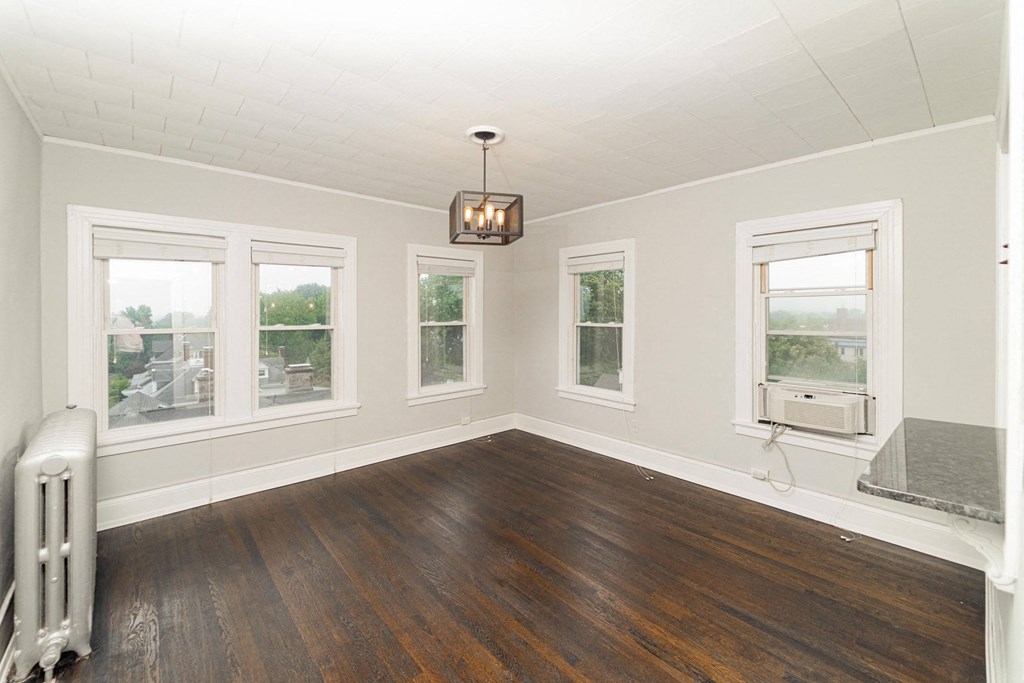 an empty living room with a wood floor and a window