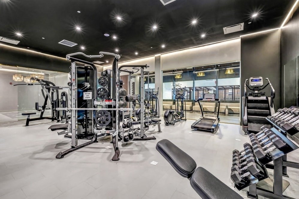 a gym with weights and cardio equipment at the mansion